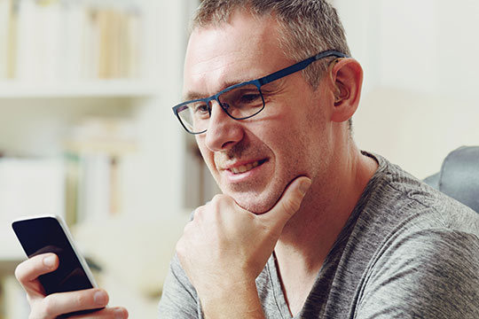 Man researching hearing aids on his phone